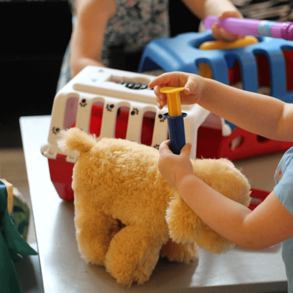 children playing vet with stuffed animals
