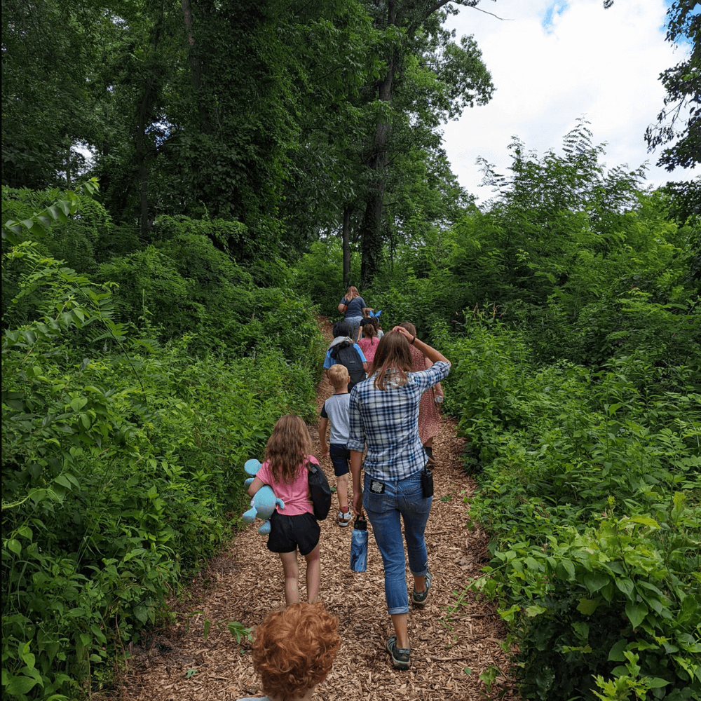Children and staff walking on a nature path on a field trip with refuge city early childhood daycare center